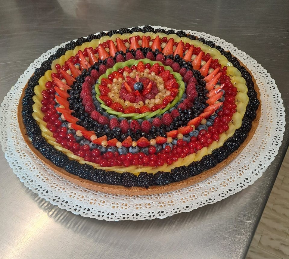 Round tart with fresh fruit and mixed berries arranged in circles