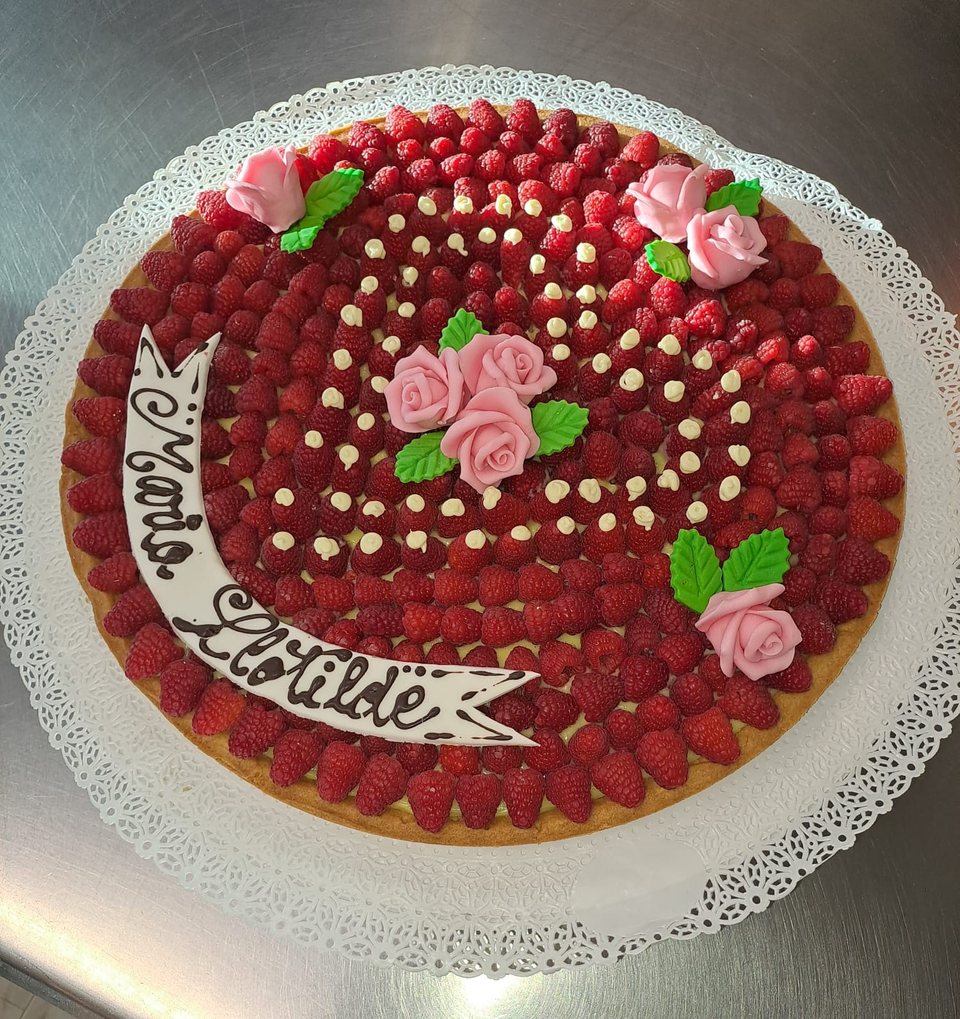 Raspberry tart with pink roses and a personalised message