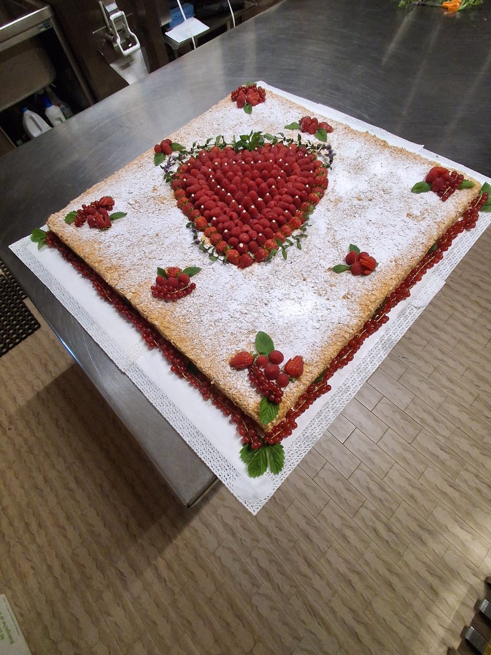 Rectangular cake with icing sugar and a heart of raspberries and strawberries